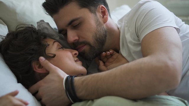 attractive couple kissing tender in morning after waking up Spbd. caring intimacy sensual moment. love. sex, marriage concept. dating or married couple looking at each other