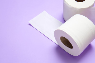 Rolls of toilet paper on color background