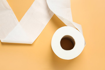 Roll of toilet paper on color background