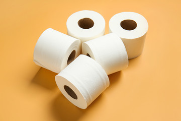 Rolls of toilet paper on color background