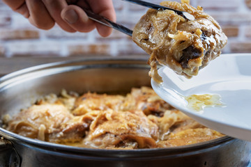 Chicken thighs are fried in a pan and served with spitz on a plate, close-up, shallow depth of field, selective focus. Homemade food concept.