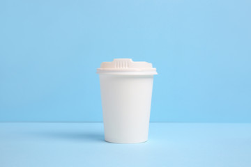 Takeaway cup for drink on color background