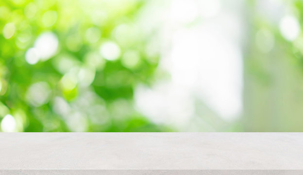 Fototapeta abstract blurred garden view form living room window with concrete table counter background for show , promote ,design banner ads on display concept 