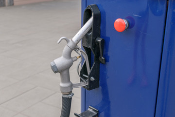 Filling station. Blue case. Red start button. Metal fuel dispensing valve with black hose.