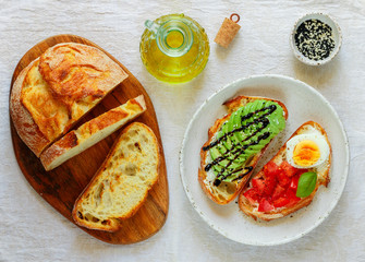 Wheat bread sandwiches with cream cheese (ricotta), avocado, eggs, tomato, Basil, black and white sesame, balsamic. Delicious healthy Breakfast for gourmets. Selective focus, top view