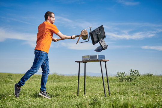 man tearing up a computer on the mountain