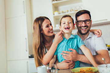 Happy family having breakfast together at home in the kitchen