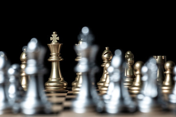 gold against silver chess pieces team on chess board, business strategy concept
