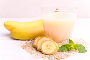 Banana juice in a glass with sliced banana and mint