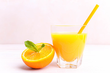 Orange juice in a glass with half an orange and mint