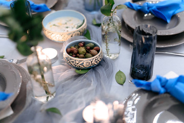 Close up of decorated table with textile, vases and candles. Delicious dishes served for banquet. Concept of catering and private hire for event