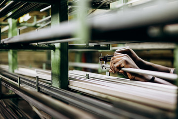 Iron and steel materials in different shape and forms lying on shelves. Storage for raw stuff on...