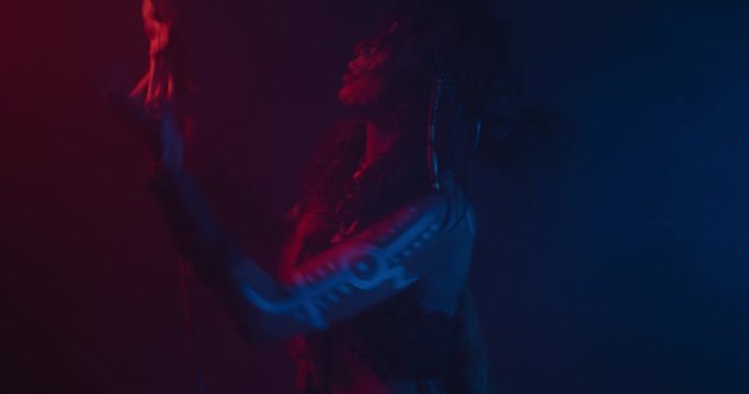 Ritual dancing with a staff of a scary shaman woman, red and blue lighting, 4k