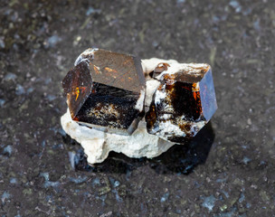 closeup of sample of natural mineral from geological collection - raw Andradite garnet rock on...