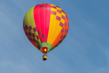Naklejka premium Colorful hot air balloon on an early morning flight at Canberra, Australia. With an isolated blue sky backdrop with copy space for text.