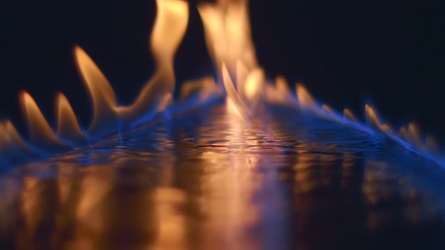 Blue wave of fire by ignited gasoline on a reflective surface and a huge fire soars up with spurts of flame. Closeup. Slow mo, slo mo, slow motion, high speed camera. V-log - High Dynamic Range