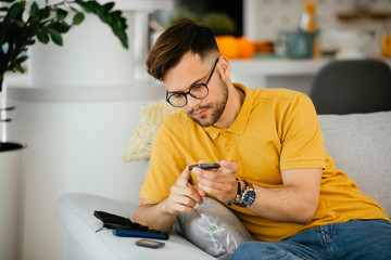Man checking blood sugar level with glucometer. Young man measuring blood sugar level.