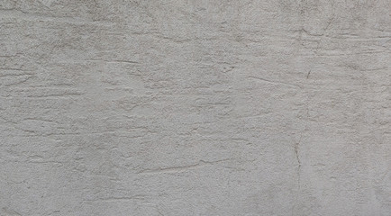 Plastered gray cement wall with horizontal scratchy structures. Gray concrete wall background with rough patterns.