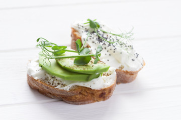 Healthy sandwiches with avocado , cream cheese and micro green. Vegan sandwiches, vegan food, healthy eating. Template with space for text , white background