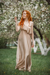 red-haired girl in a blooming garden