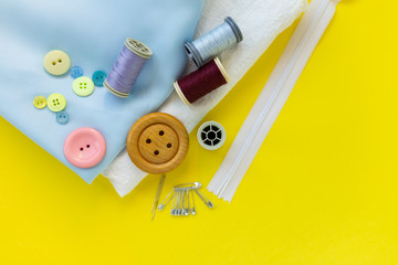 quilting, embroidery and sewing tools on the table. , floss, hoop. cloth materials on yellow background. Flatlay copy space