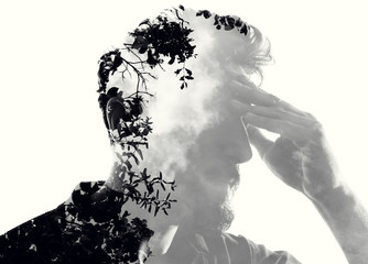 Double exposure of pensive man in the tree and clouds