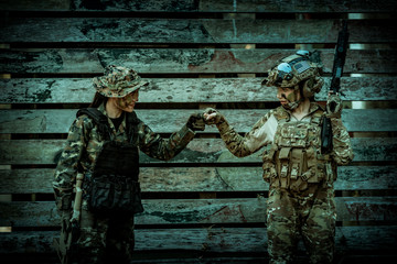Two woman soldiers wearing safety uniform show teamwork tracking by hand in soldier training...