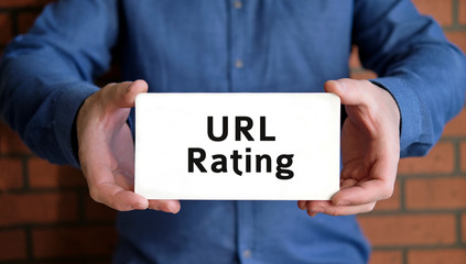 Url rating - seo concept check the rank of the site in the hands of a young man in a blue shirt
