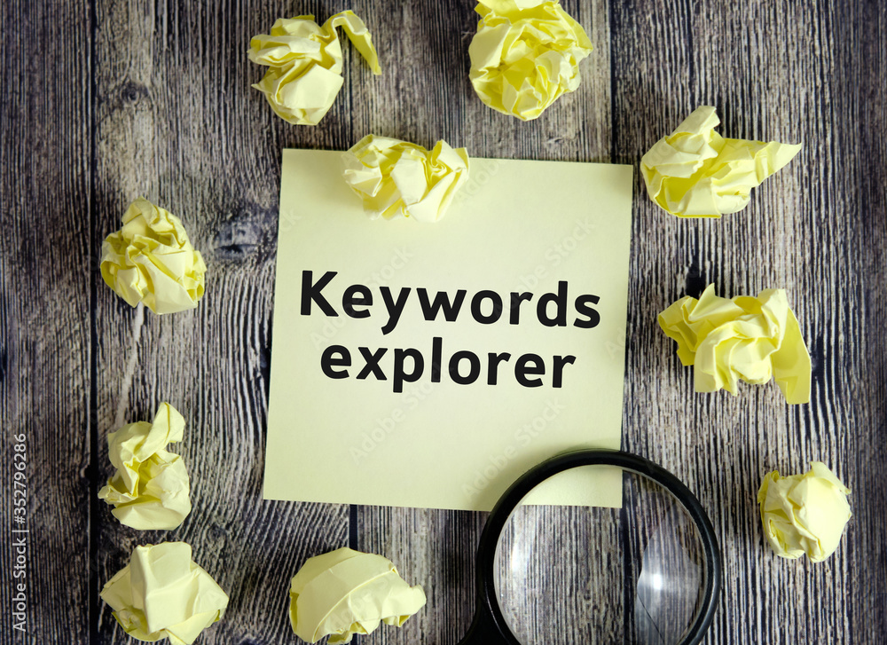 Poster keyword explorer - text on yellow note sheets on a dark wooden background with crumpled sheets and a