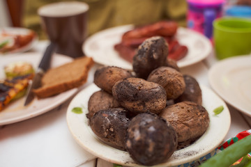 A few pieces of baked potatoes on the fire. Lying on a white plate