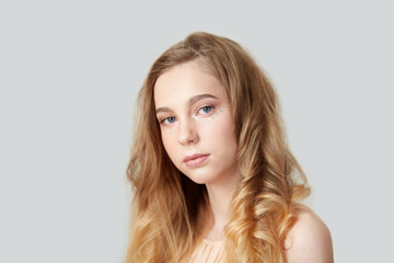 Portrait of a beautiful young girl with bright wavy hair.