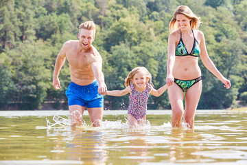 Familie mit Tochter beim Baden im See