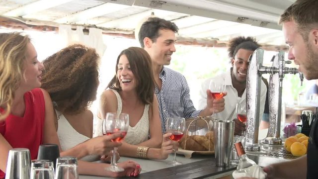 Group Of Friends Enjoying Drink At Outdoor Bar