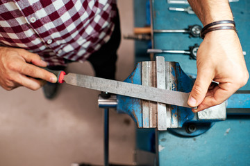 Grinding a block of metal with a file