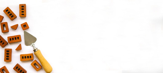 Billboard. Small bricks and trowel on a white background. Construction and repair.