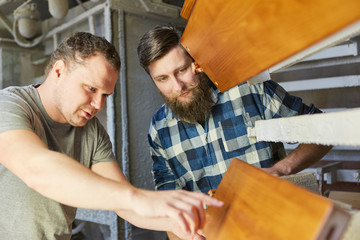 Lehrling und Ausbilder besprechen Werkstück