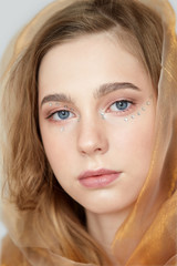 Obraz premium Close-up face of a beautiful young girl with makeup and rhinestones.