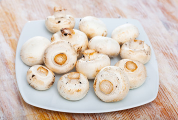 Fresh champignons on wooden surface