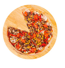 Tasty pizza with mushrooms, corn, cherry tomatos, courgettes and bell peppers, without one slice on a wooden platter, isolated on white background with clipping path, top view