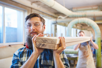 Schreiner Lehrlinge tragen Balken aus Holz