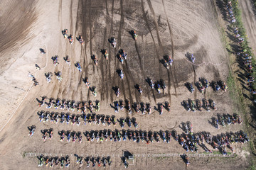 Motocross riders ride on a dust terrain track