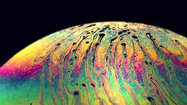colorful soap bubble swings in all directions under a lamp. Enjoyment of life.