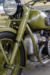 Fototapeta na wymiar Fragment of an old military motorcycle. A khaki military motorcycle.