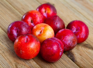Tasty ripe red plum on a wooden surface