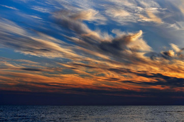 sunset clouds in the evening sky over the water