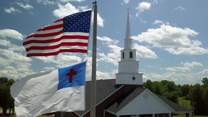 Aerial US and Christian Flag fly outside church