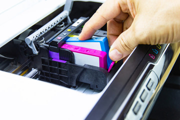 Technicians are install setup the ink cartridge of a inkjet printer the device of office automate...
