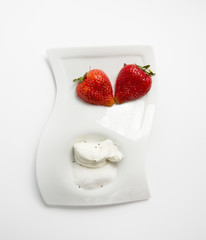 beautiful strawberries on a white plate with sugar and sour cream view from above 