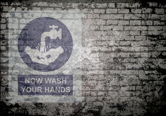Grunge decayed faded brick wall background with now wash your hands message sign to stop the spread of the worldwide pandemic