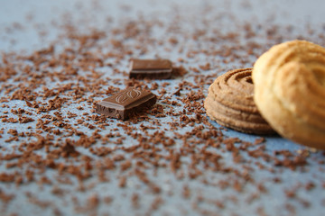 Macro photo of Broken pieces Chocolate bar and dark and white cookie, pastry, cracker, biscuit. Dark chocolate stack with brown powder on a stone background with copy space.